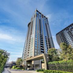 Modern high-rise residential building with clear blue sky and greenery