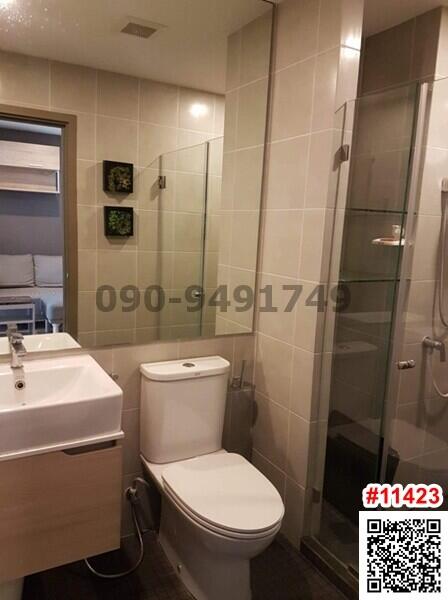 Modern, compact bathroom with light tiled walls and glass shower