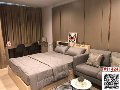 Modern bedroom with integrated living area featuring a bed, couch, and subtle decor