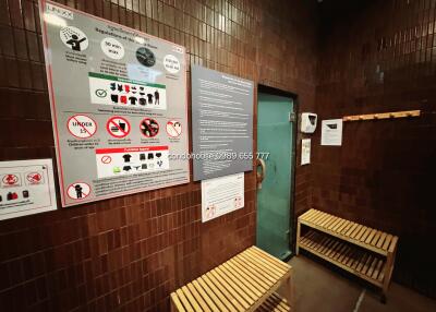 Modern sauna room with wooden benches and informational posters