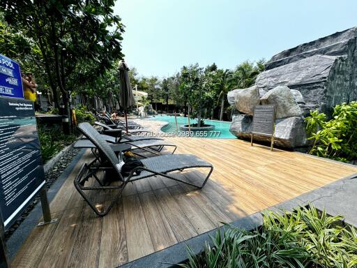 Luxurious outdoor pool area with wooden deck and sun loungers