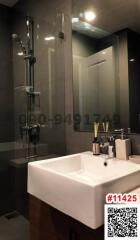 Modern bathroom interior with a glass shower, well-lit vanity area, and stylish fixtures