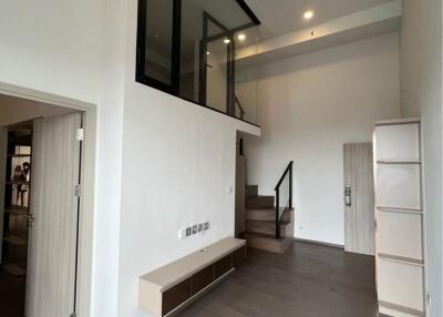 Modern living room with high ceiling and staircase