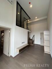 Modern living room with high ceiling and staircase