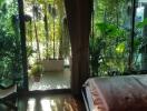 Cozy bedroom with a view of lush greenery through floor-to-ceiling windows