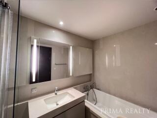 Modern bathroom with large mirror and well-lit vanity