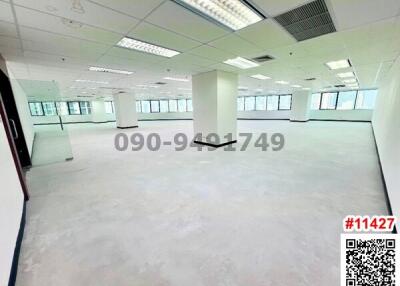 Spacious empty office space with large windows and column