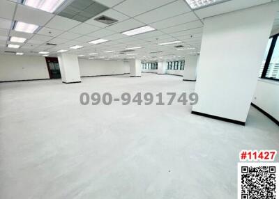 Spacious empty office space with white columns and large windows