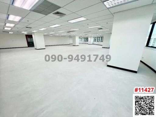 Spacious empty office space with white columns and large windows