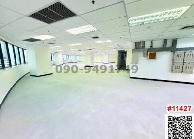 Spacious empty office space with large windows and modern lighting