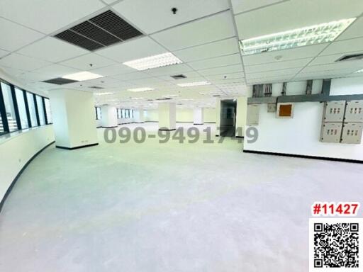 Spacious empty office space with large windows and modern lighting