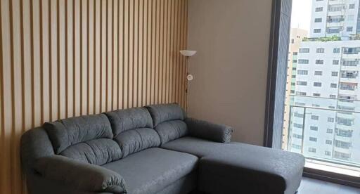 Modern living room with gray sofa and wooden panel wall