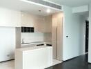 Modern kitchen with white cabinetry and black countertops in a new apartment