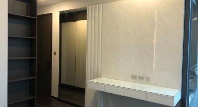 Modern bedroom with a sleek white wall-mounted floating console and a full-length sliding door wardrobe