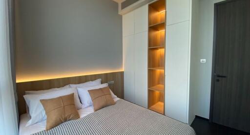 Modern bedroom with ambient lighting and built-in shelving