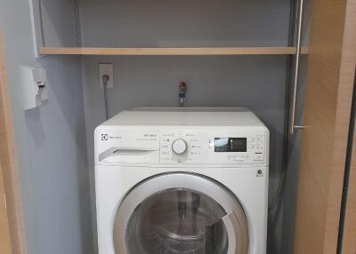 Efficient utility room with modern washing machine and storage shelves