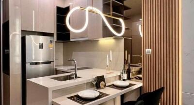 Modern kitchen with integrated appliances and stylish lighting fixtures