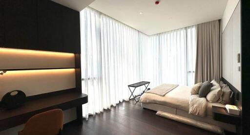 Modern bedroom with ample natural light and chic furnishings