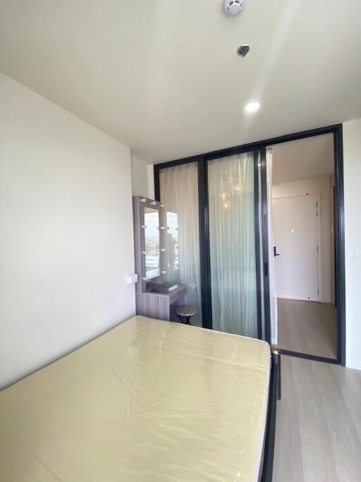 Modern bedroom with large windows and glass door leading to balcony