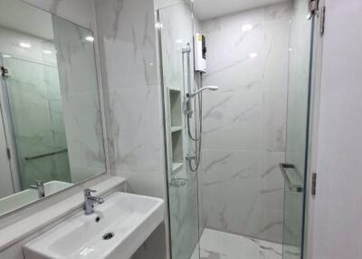 Modern bathroom interior with marble tiles and glass shower