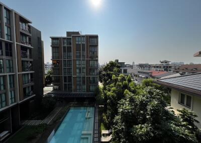 Exterior view of modern residential buildings with a swimming pool and landscaped areas