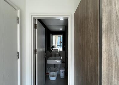 Modern bathroom with open door view showcasing sink and mirror