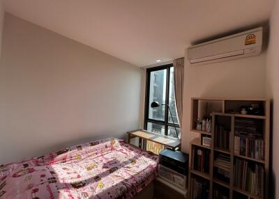 Cozy bedroom with natural lighting, air conditioning, and bookshelf
