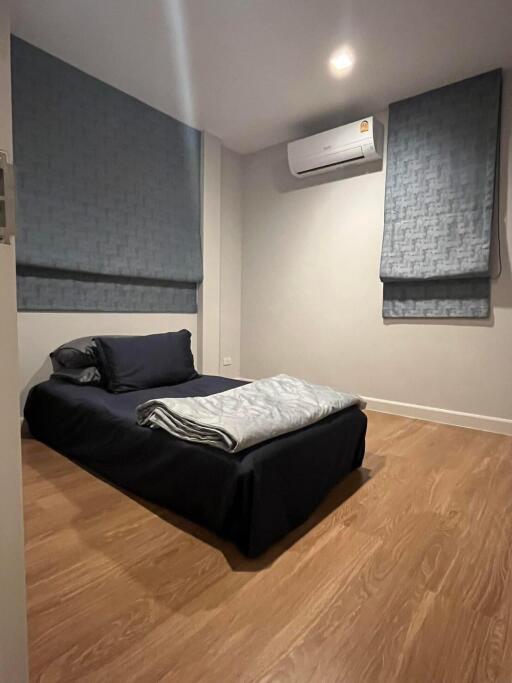 Modern bedroom with wooden flooring and air conditioning unit