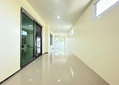 Spacious and bright hallway with large windows and glossy tiled flooring