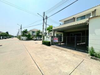 Suburban street view with modern houses and for-sale sign