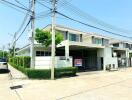 Spacious two-story house for rent with lush greenery and a prominent 'For Rent' sign