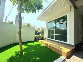 Stylish outdoor patio with large windows and artificial grass