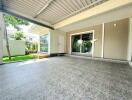 Spacious patio area with gray tiled flooring and modern sliding doors