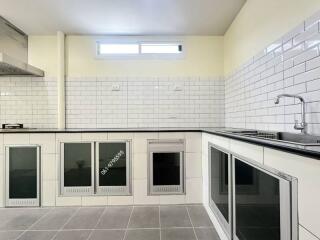 Spacious modern kitchen with white subway tiles and integrated appliances