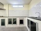 Spacious modern kitchen with white subway tiles and integrated appliances