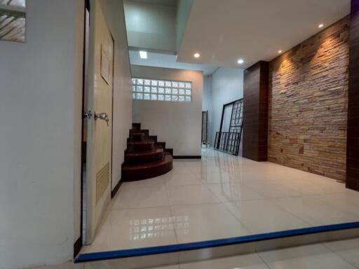 Spacious hallway with staircase and elegant stone wall