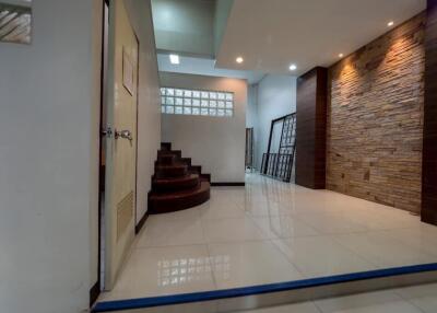 Spacious hallway with staircase and elegant stone wall