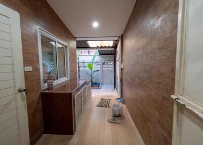Well-lit hallway with wooden paneling and outdoor view