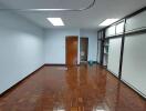 Spacious office room with parquet flooring and large windows