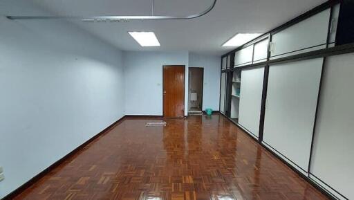 Spacious office room with parquet flooring and large windows