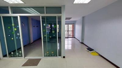 Spacious office space with glass partition and tiled flooring
