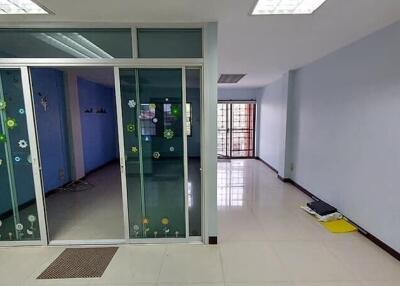 Spacious office space with glass partition and tiled flooring