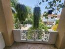 Sunny balcony with ornate railing and lush greenery