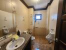 Spacious and well-equipped bathroom with beige tiles and multiple sanitary facilities