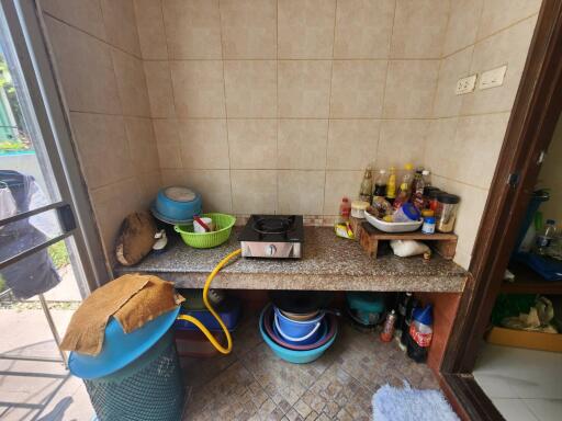 Compact kitchen storage area with various cooking utensils and supplies