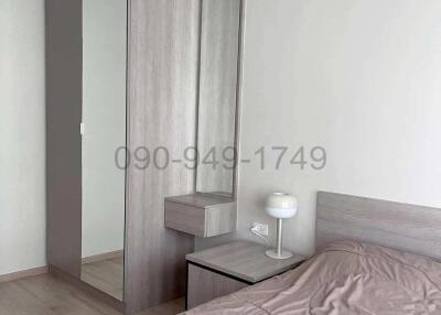 Minimalist style bedroom with large mirror and modern furnishings