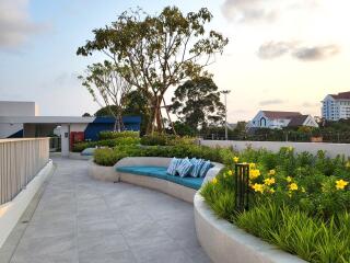 Modern outdoor communal area with seating and landscaping at dusk