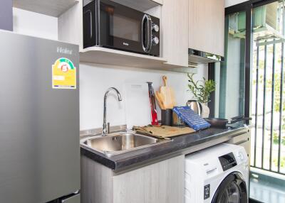 Modern compact kitchen with appliances and balcony access