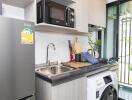 Modern compact kitchen with appliances and balcony access