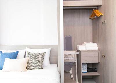 Modern bedroom with neatly arranged bedding and a built-in wardrobe